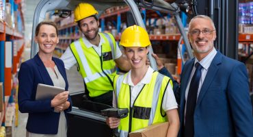 Warehouse manager and client standing with co-workers 4PL supply chain resilience