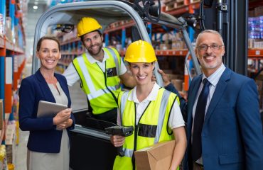 Warehouse manager and client standing with co-workers 4PL supply chain resilience